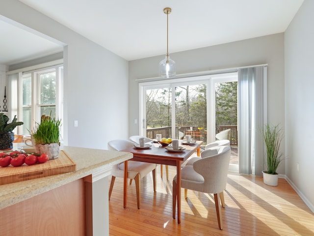 dining space featuring light wood-type flooring and baseboards