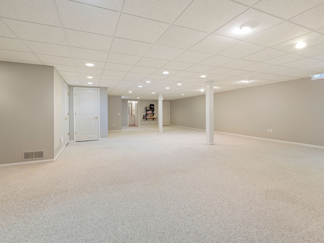 finished below grade area featuring visible vents, light carpet, recessed lighting, a paneled ceiling, and baseboards