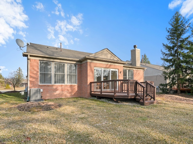 back of house with central air condition unit, brick siding, a wooden deck, and a lawn