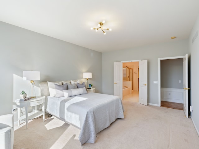 bedroom featuring light carpet and ensuite bath