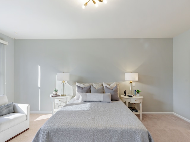 bedroom with light colored carpet and baseboards