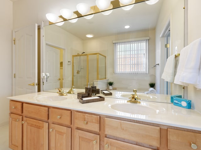 bathroom with a sink, a garden tub, double vanity, and a shower stall