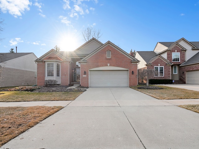 traditional-style home featuring concrete driveway, a garage, and brick siding