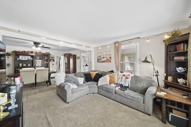 carpeted living area with a ceiling fan