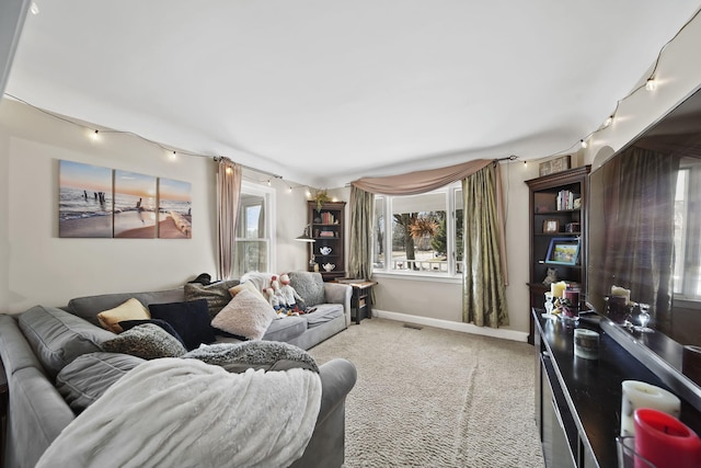 living area featuring rail lighting, light carpet, and a wealth of natural light
