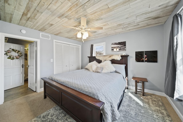 bedroom featuring a closet, wooden ceiling, baseboards, visible vents, and light colored carpet