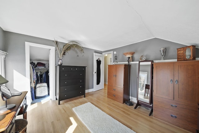 bedroom featuring lofted ceiling, a closet, and wood finished floors