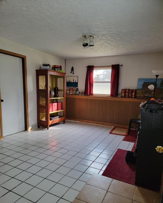 sitting room featuring tile patterned flooring and a textured ceiling