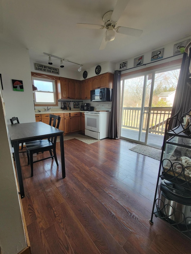 kitchen featuring black microwave, dark wood finished floors, light countertops, white electric stove, and a ceiling fan