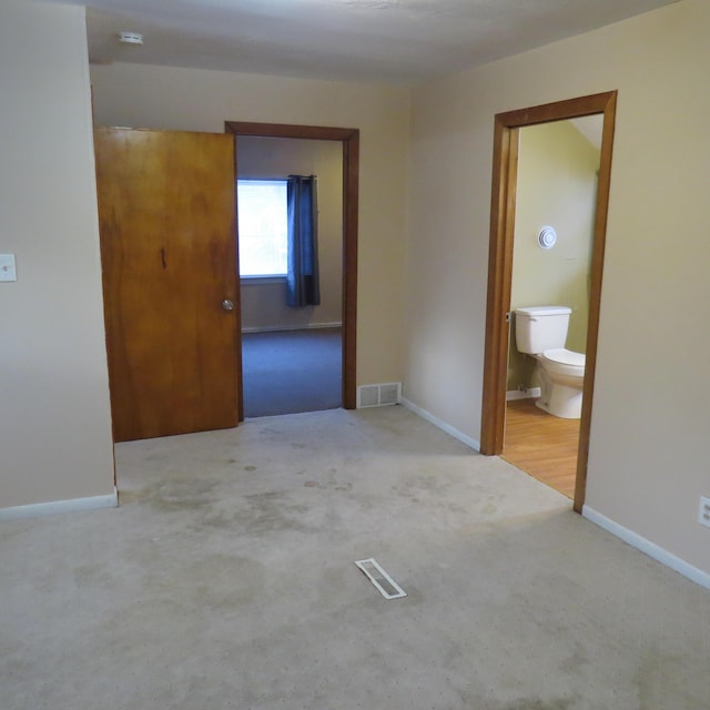 unfurnished bedroom featuring visible vents, baseboards, and carpet