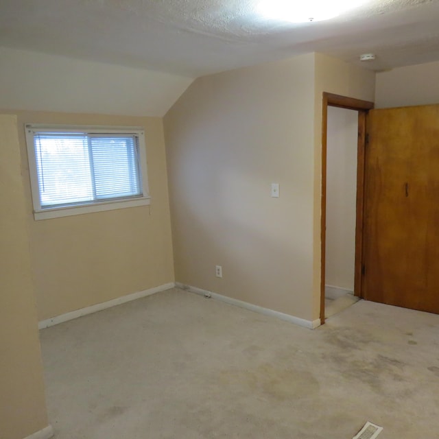 interior space with baseboards, lofted ceiling, and carpet flooring