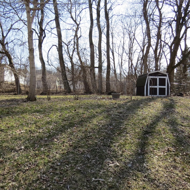 view of yard featuring fence, an outdoor structure, and a shed