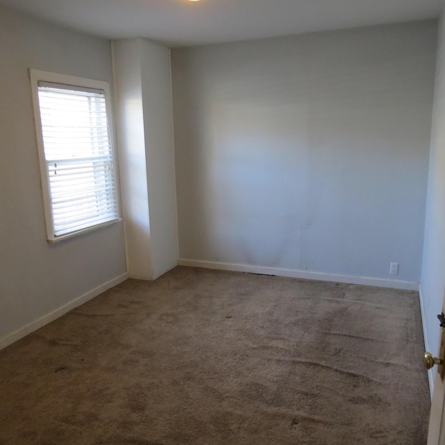 empty room featuring carpet flooring and baseboards