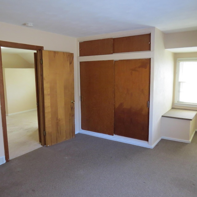 unfurnished bedroom featuring a closet, baseboards, and carpet