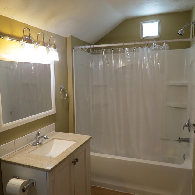 bathroom with lofted ceiling, vanity, and shower / tub combo