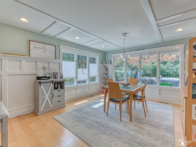 dining space with a decorative wall, recessed lighting, light wood-style floors, and visible vents