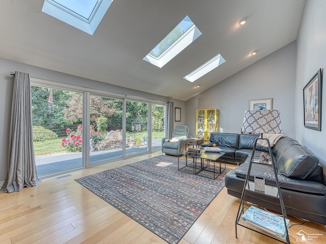 living room with visible vents, recessed lighting, a skylight, wood finished floors, and high vaulted ceiling