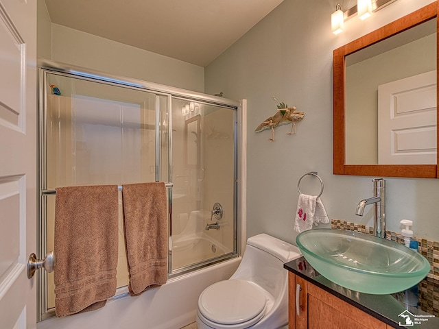 full bath featuring vanity, toilet, and bath / shower combo with glass door