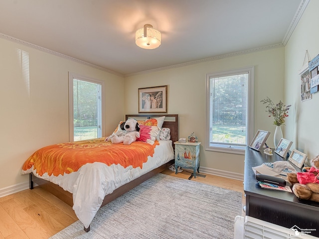 bedroom with crown molding, baseboards, and wood finished floors