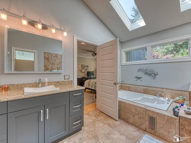 ensuite bathroom featuring vanity, a garden tub, visible vents, ensuite bath, and lofted ceiling with skylight