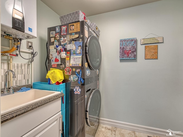 washroom with baseboards, water heater, laundry area, stacked washing maching and dryer, and a sink