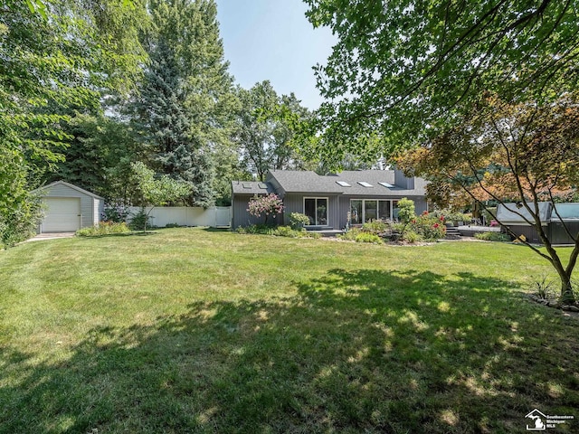 view of yard featuring a garage, an outdoor structure, and fence