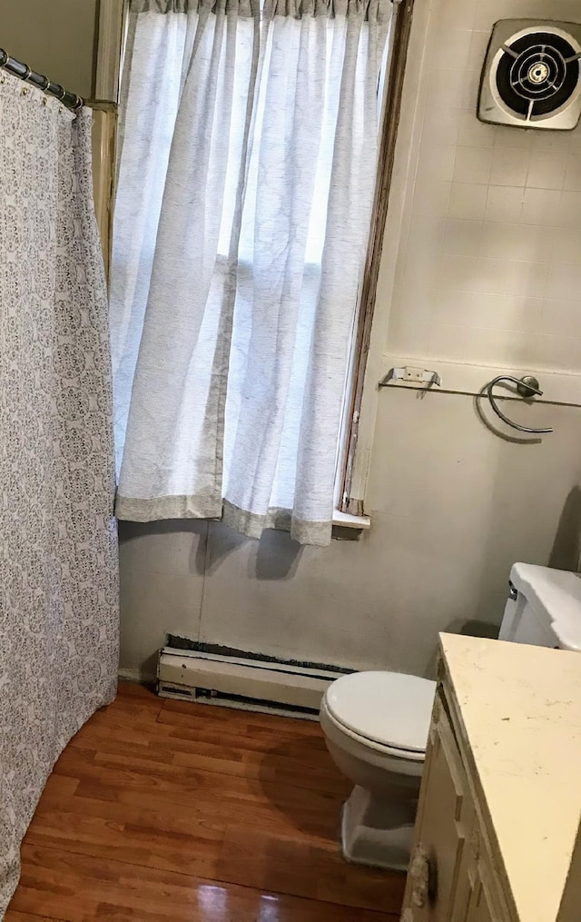 full bathroom with vanity, toilet, wood finished floors, and a baseboard radiator