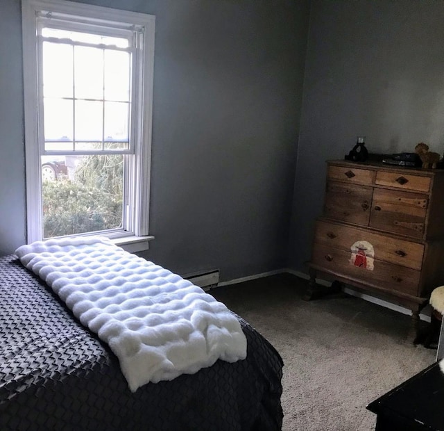 carpeted bedroom featuring baseboard heating, multiple windows, and baseboards