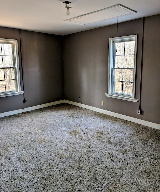 empty room with attic access, baseboards, and carpet floors