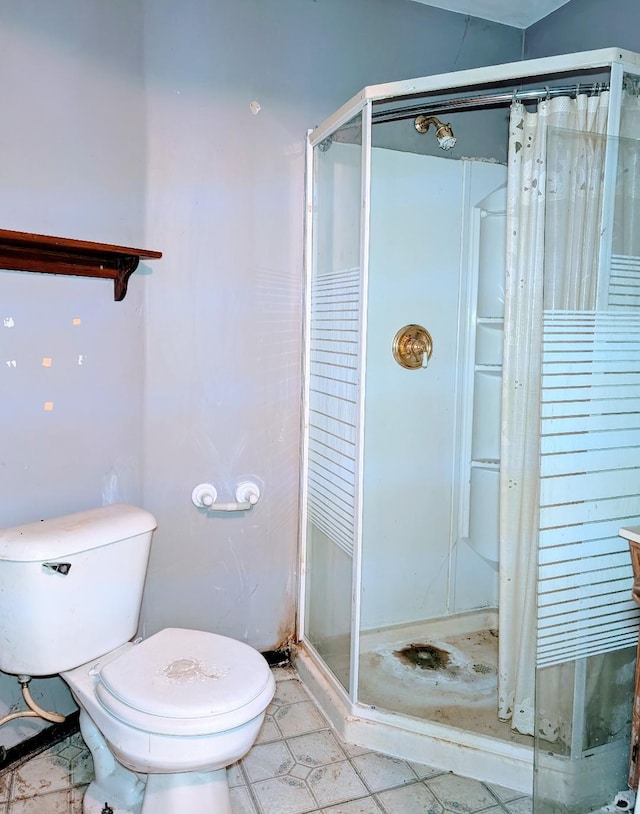 bathroom with a shower stall and toilet