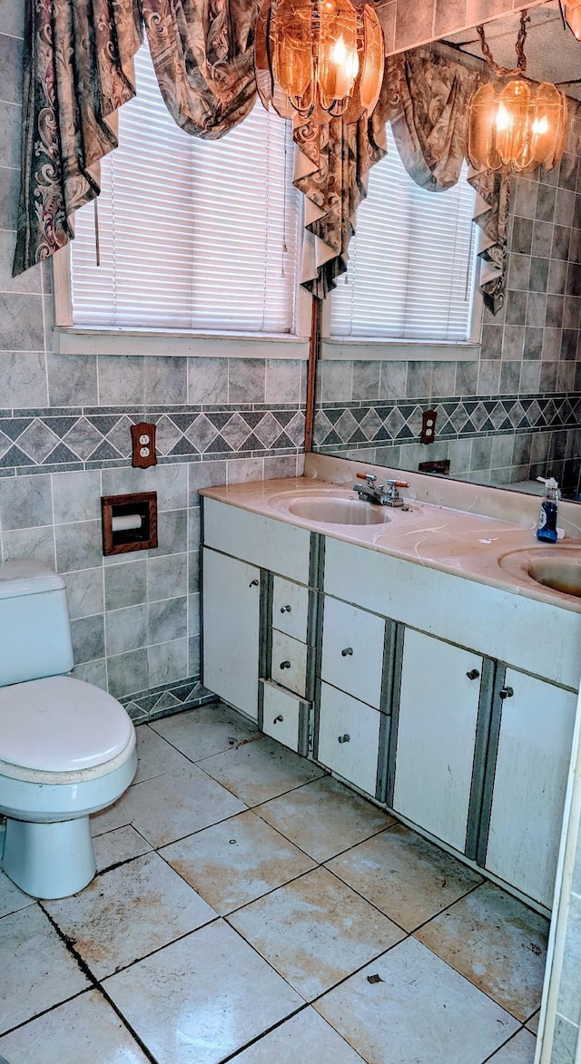 bathroom featuring vanity, tile walls, toilet, and a chandelier