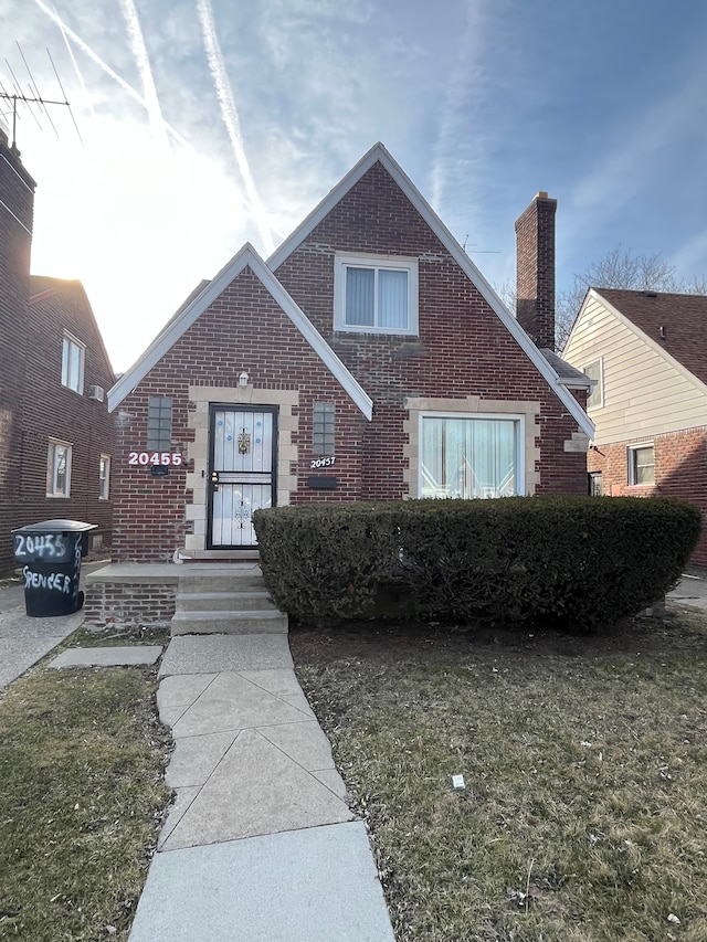 view of front facade featuring brick siding and a chimney