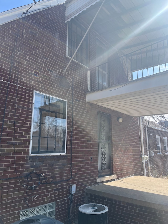 view of home's exterior with brick siding and central AC unit