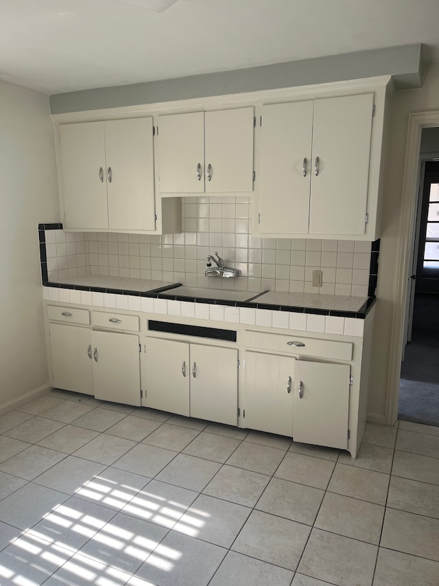 kitchen with light tile patterned floors, backsplash, and tile counters