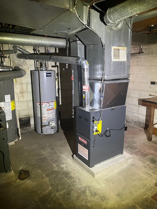 utility room featuring gas water heater and heating unit