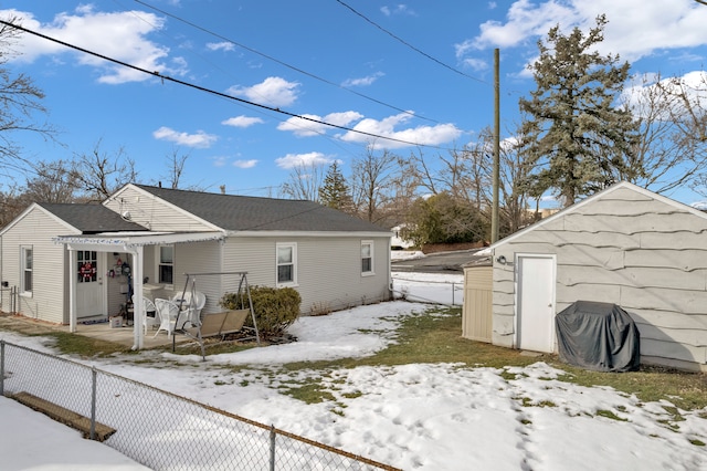 view of snowy exterior with a patio area and fence