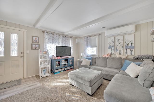 living area featuring a wealth of natural light, beam ceiling, and a wall mounted AC