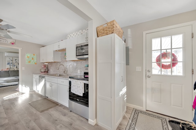 kitchen featuring a sink, tasteful backsplash, stainless steel appliances, light countertops, and ceiling fan