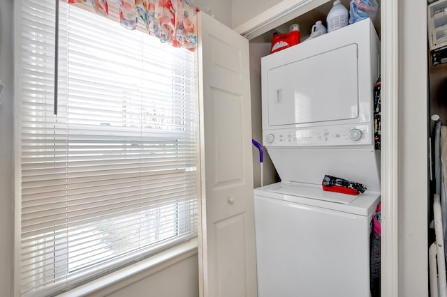 clothes washing area featuring stacked washer / drying machine and laundry area