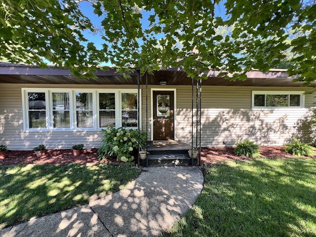 entrance to property featuring a yard