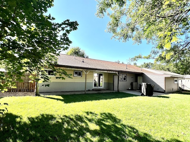 back of property featuring a lawn, a patio, and fence