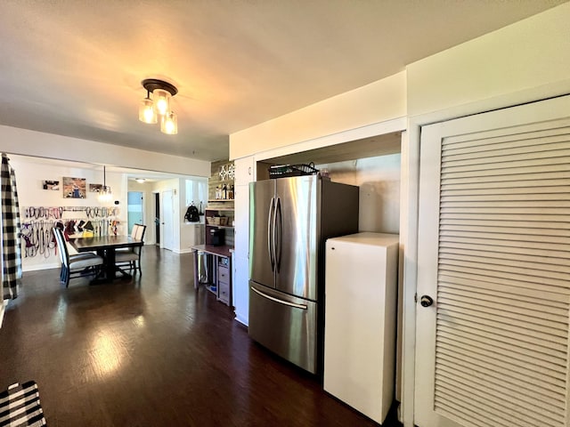 kitchen featuring white cabinets, dark wood-style flooring, and freestanding refrigerator