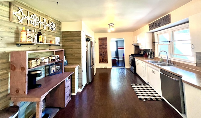 kitchen featuring dark wood finished floors, a sink, stainless steel appliances, white cabinets, and under cabinet range hood