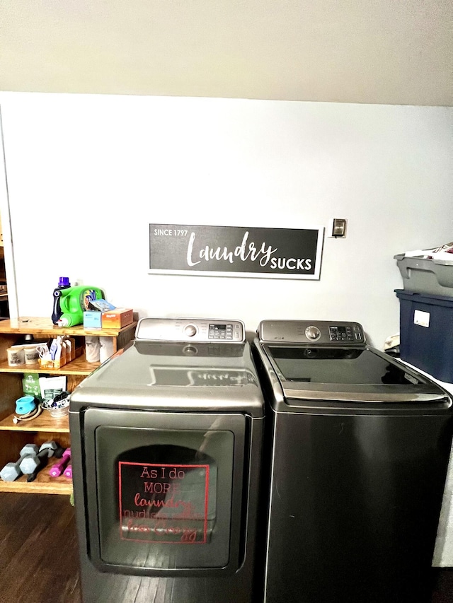 laundry room with laundry area, wood finished floors, and washing machine and dryer