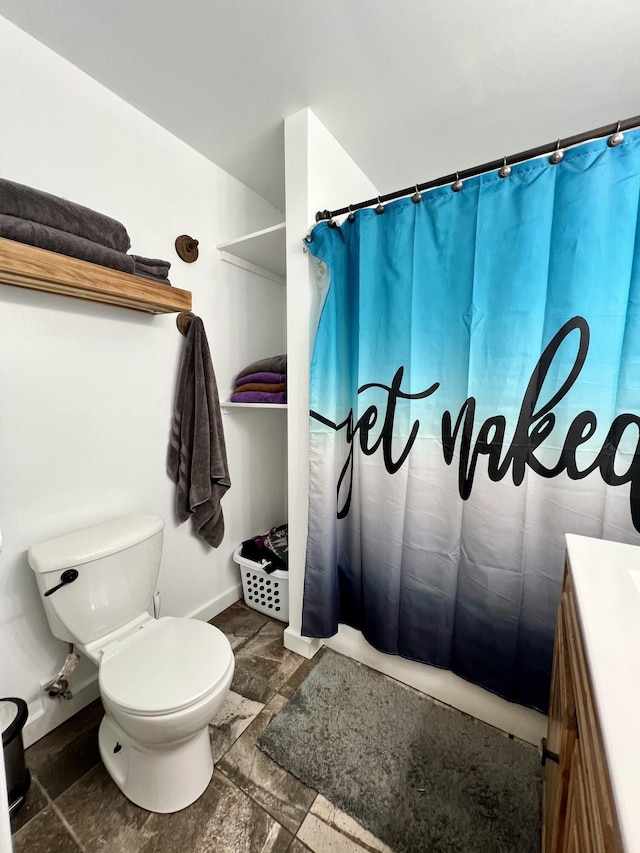 full bath with vanity, baseboards, stone finish floor, curtained shower, and toilet