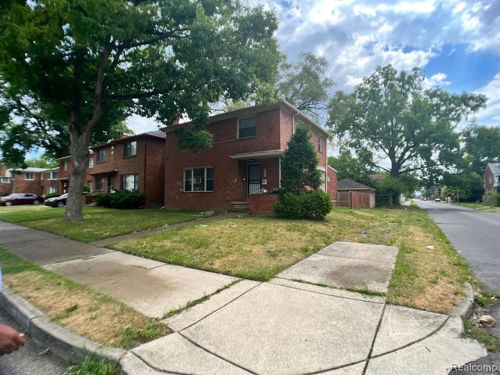 view of front of property featuring a front lawn and brick siding