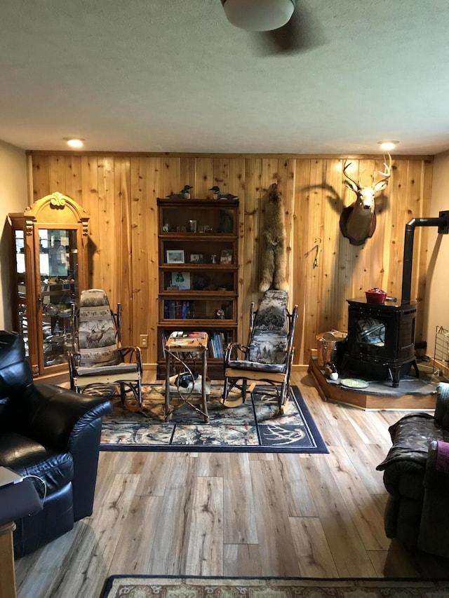 living room featuring a wood stove and wood finished floors