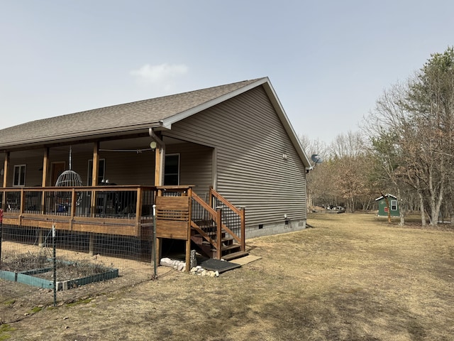 exterior space with crawl space, a wooden deck, and roof with shingles