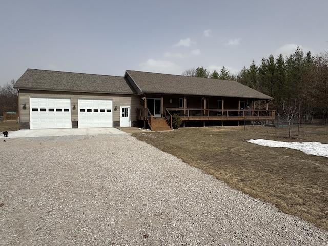 ranch-style home with a garage, a porch, driveway, and a shingled roof