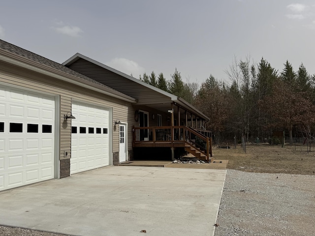 view of side of property featuring concrete driveway and an attached garage